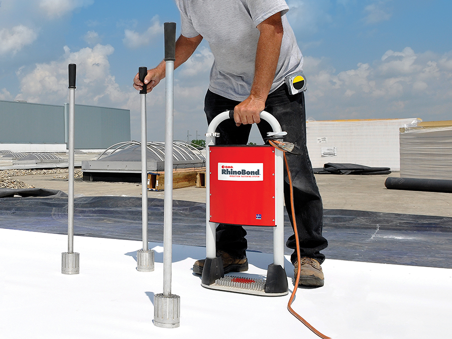 Roofing contractor installing a RhinoBond flat roofing system.