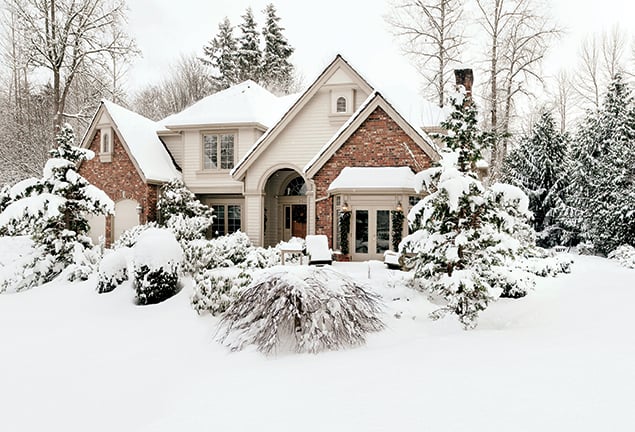 A suburban home covered in snow during winter. 