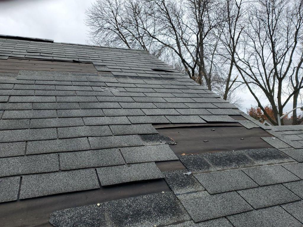 Asphalt roof with shingles blown off. 