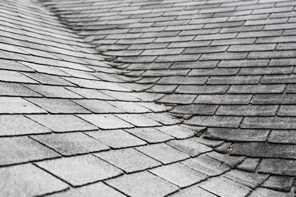 Poorly installed asphalt shingles with asphalt shingles overlapping in the roof's valley. 