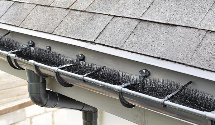 Bottle brush guards sitting in a gutter system.