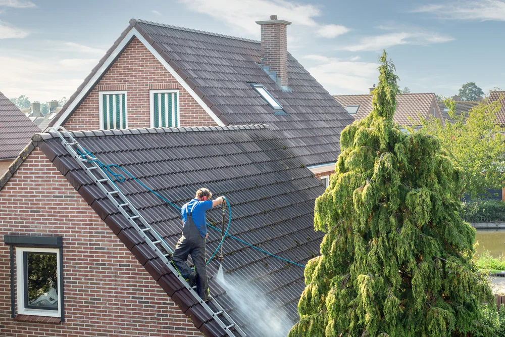 Homeowner spraying water on a roof.