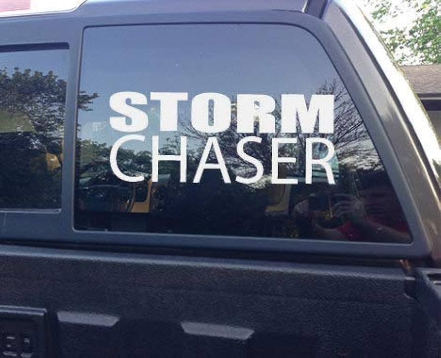 A close-up of a black van with "Storm Chaser" written on the window.