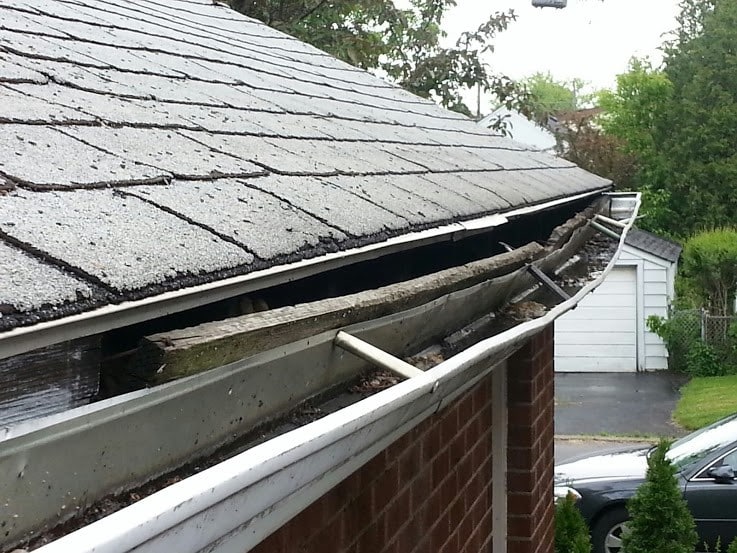 Clogged aluminum gutters that are beginning to pull away from the home. 