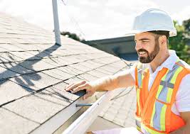 Roofing professional in a vest and hard hat inspection a roof's edge.