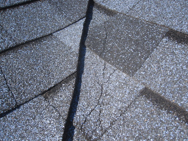 Close-up of a cracked asphalt shingle. 