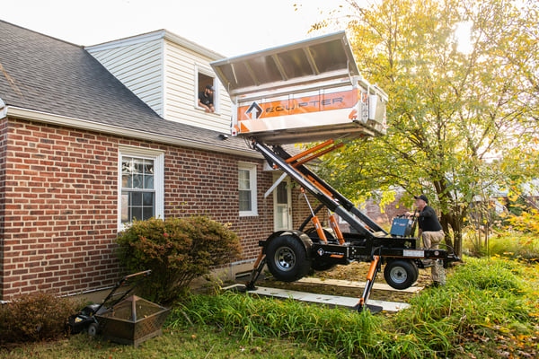 Roofing equipter raised up to a home's roof line. 